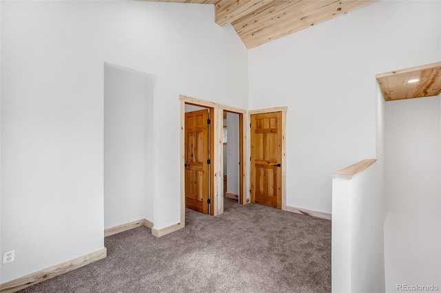 hall with beamed ceiling, high vaulted ceiling, carpet floors, and wooden ceiling