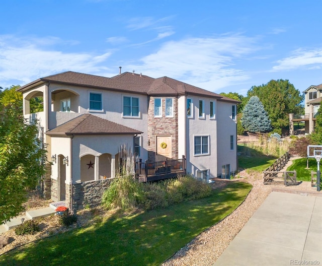 10215 W Wesley Dr, Lakewood, CO 80227 - mediterranean / spanish house with a front yard, stucco siding, stone siding, and a patio