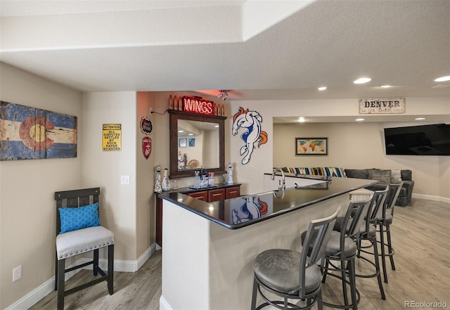 10215 W Wesley Dr, Lakewood, CO 80227 - bar featuring recessed lighting, baseboards, a textured ceiling, light wood finished floors, and indoor wet bar