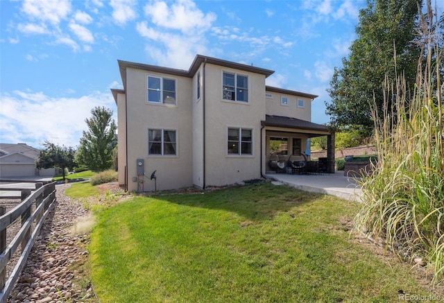 rear view of property featuring a lawn and a patio