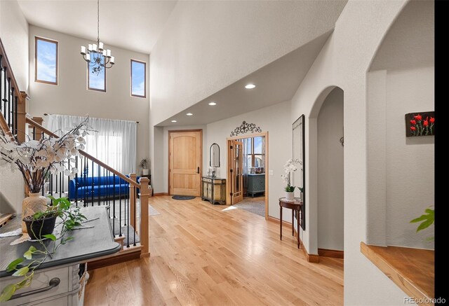 10215 W Wesley Dr, Lakewood, CO 80227 - foyer entrance featuring plenty of natural light, stairs, light wood-type flooring, and arched walkways