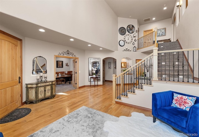 entryway featuring a towering ceiling and hardwood / wood-style flooring