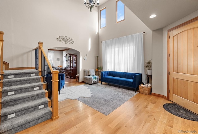 10215 W Wesley Dr, Lakewood, CO 80227 - interior space with stairway, baseboards, a towering ceiling, arched walkways, and wood finished floors