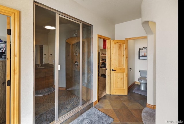 bathroom featuring an enclosed shower and toilet