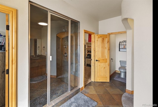 10215 W Wesley Dr, Lakewood, CO 80227 - bathroom featuring vanity, a spacious closet, toilet, baseboards, and a stall shower