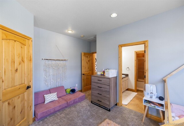 carpeted bedroom featuring ensuite bath