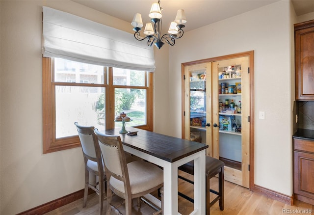 dining room with an inviting chandelier and light hardwood / wood-style flooring