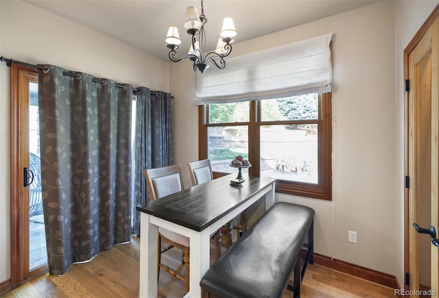 dining area with light hardwood / wood-style flooring and a chandelier