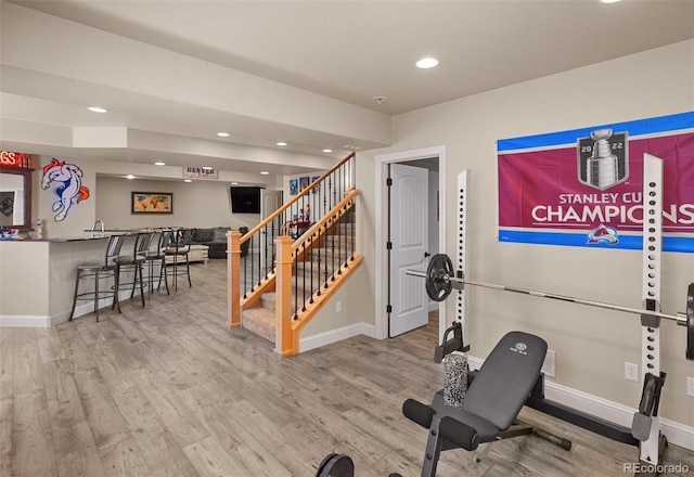 exercise room with wood-type flooring and bar area