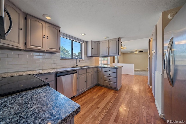 1923 S Newark Way, Aurora, CO 80014 - kitchen featuring appliances with stainless steel finishes, gray cabinetry, light wood-style floors, backsplash, and ceiling fan