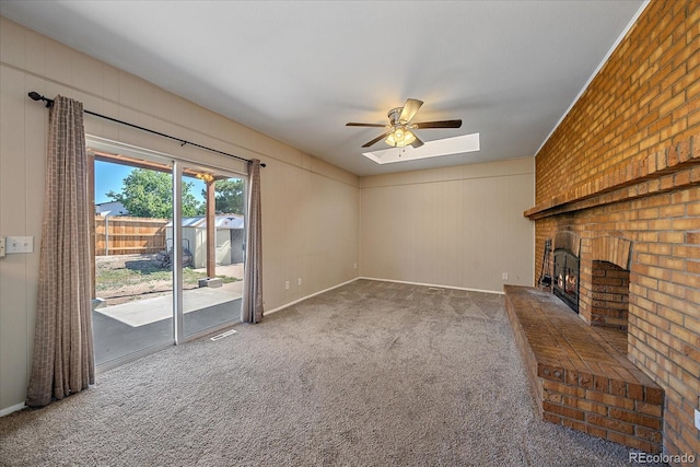1923 S Newark Way, Aurora, CO 80014 - unfurnished living room with a ceiling fan, carpet, a brick fireplace, and a skylight