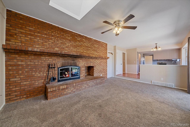 1923 S Newark Way, Aurora, CO 80014 - unfurnished living room featuring a fireplace, ceiling fan, a chandelier, carpet flooring, and brick wall