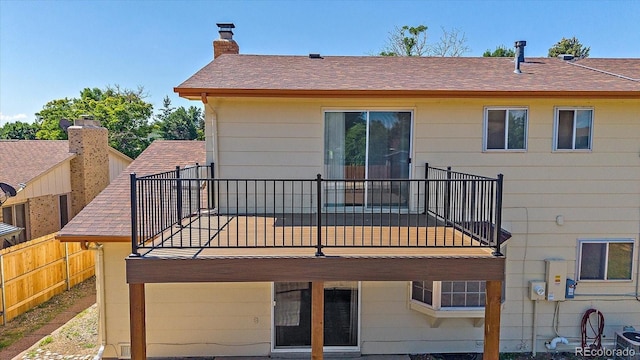 1923 S Newark Way, Aurora, CO 80014 - back of house featuring a balcony, roof with shingles, and a chimney