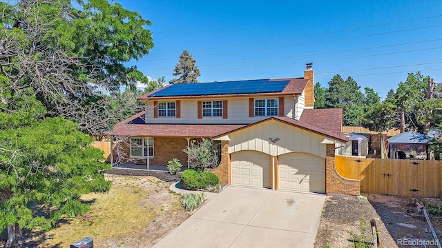 1923 S Newark Way, Aurora, CO 80014 - traditional-style home featuring brick siding, solar panels, concrete driveway, roof with shingles, and a chimney