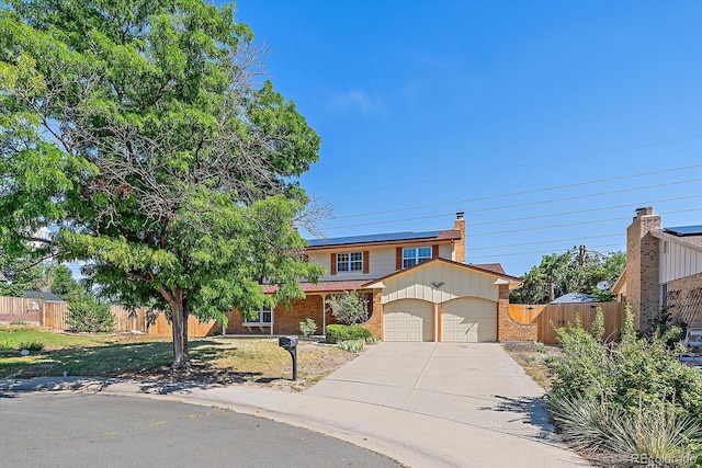 1923 S Newark Way, Aurora, CO 80014 - view of front of home with a garage, roof mounted solar panels, brick siding, concrete driveway, and a chimney