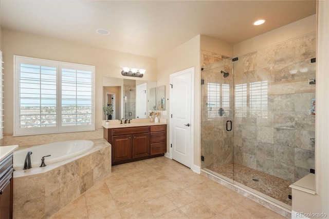 bathroom with a stall shower, a garden tub, and vanity