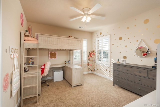 bedroom with light colored carpet, a ceiling fan, baseboards, visible vents, and wallpapered walls