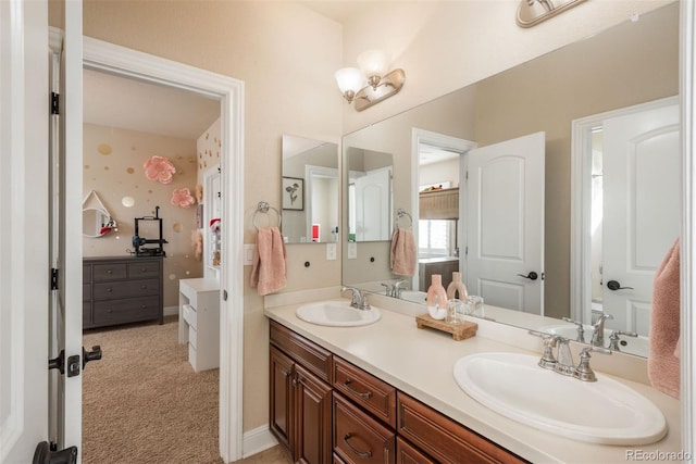 full bath featuring double vanity, a sink, and baseboards