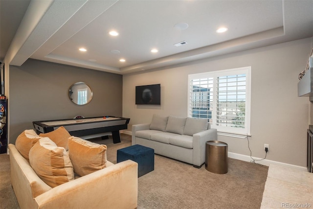 living area featuring a tray ceiling, recessed lighting, visible vents, and baseboards