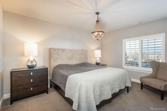 carpeted bedroom featuring a chandelier, visible vents, and baseboards