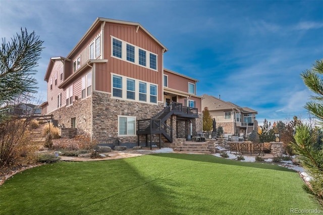 rear view of house with a patio, stairs, stone siding, a lawn, and board and batten siding