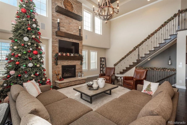 living area featuring a wealth of natural light, stairs, a fireplace, and wood finished floors