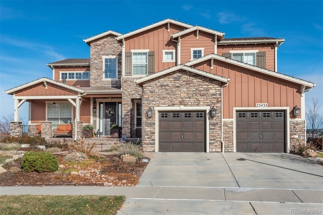 craftsman inspired home featuring driveway, stone siding, a porch, and board and batten siding