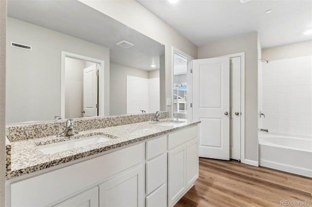 bathroom featuring shower / bath combination, vanity, and wood-type flooring