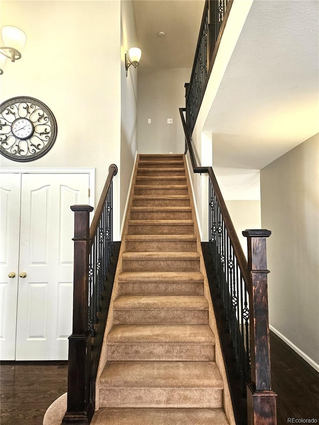 staircase featuring baseboards and wood finished floors