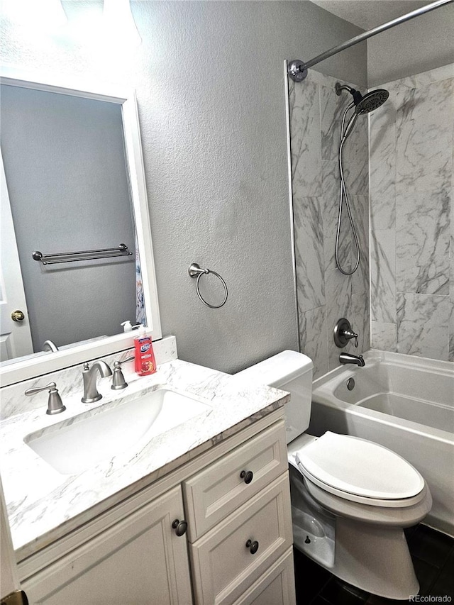 bathroom featuring toilet, shower / bathing tub combination, vanity, and a textured wall
