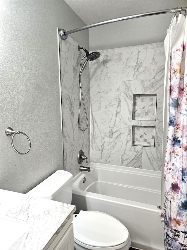 bathroom featuring a textured wall, shower / bath combo, vanity, and toilet