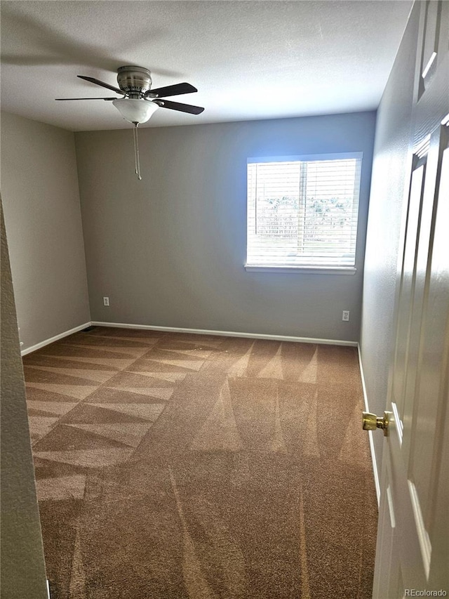 spare room with ceiling fan, carpet floors, and baseboards
