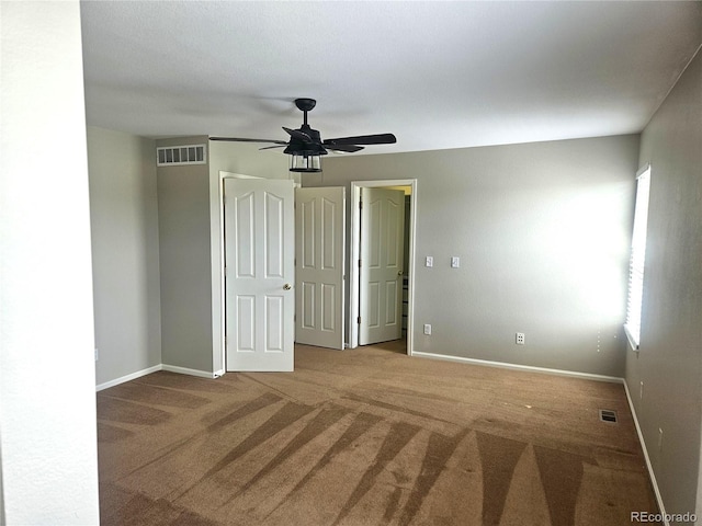 interior space featuring ceiling fan, baseboards, carpet, and visible vents