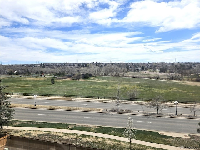 view of road with sidewalks, curbs, and a rural view