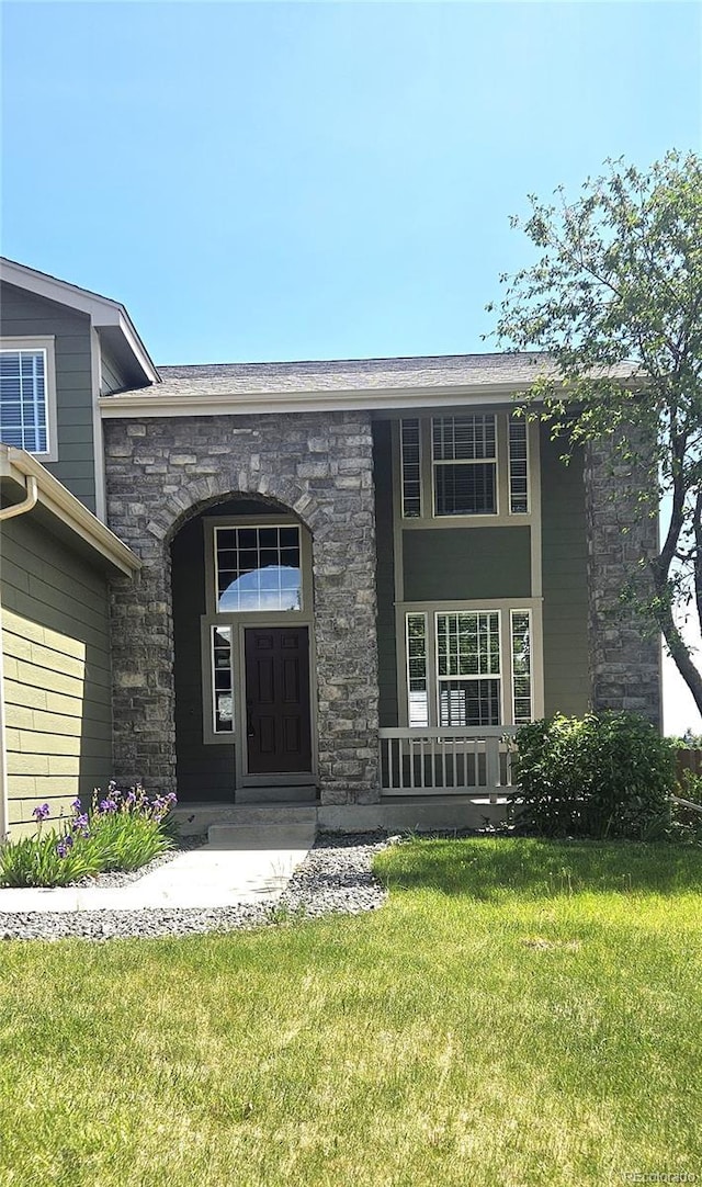 21580 Longs Peak Ln, Parker, CO 80138 - property entrance with stone siding, a yard, and covered porch