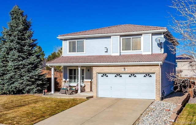 view of front property with a garage, covered porch, and a front lawn