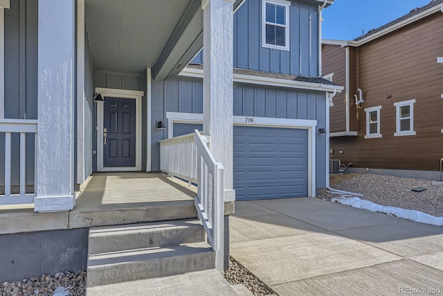 view of exterior entry featuring a garage, board and batten siding, and concrete driveway