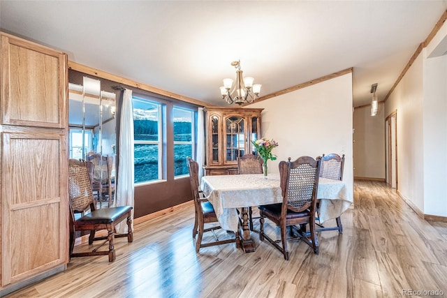 dining room with light wood-type flooring, a notable chandelier, and crown molding