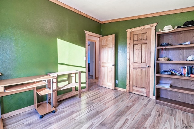 bedroom featuring ornamental molding and light hardwood / wood-style flooring