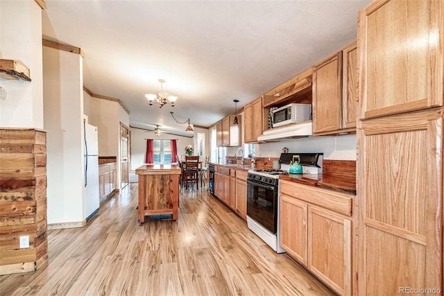 kitchen with white appliances, light brown cabinets, a kitchen island, light wood-style flooring, and a notable chandelier