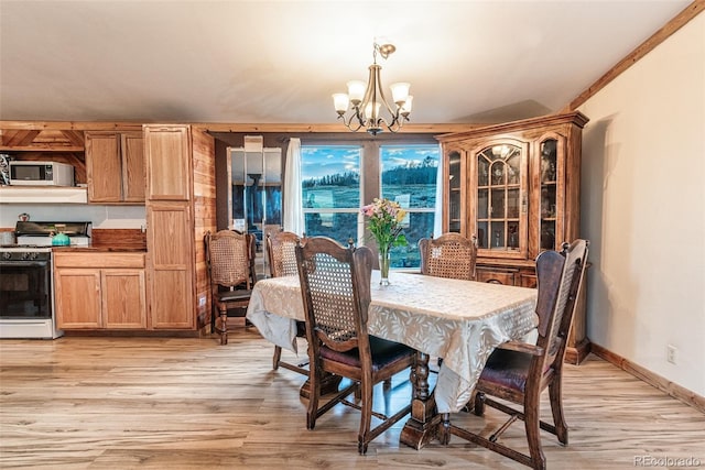 dining room featuring light wood finished floors, baseboards, and an inviting chandelier