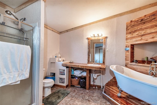 full bathroom with a soaking tub, a sink, a shower stall, toilet, and a textured wall