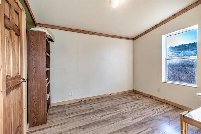 spare room with light wood-style flooring, crown molding, and baseboards