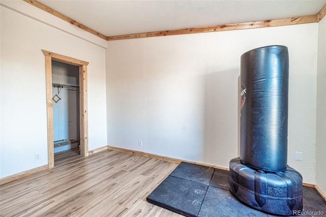 workout room with baseboards and wood finished floors