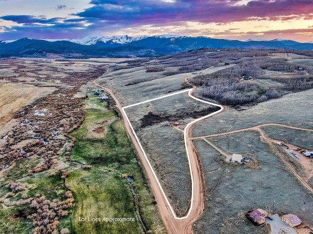 aerial view at dusk featuring a mountain view