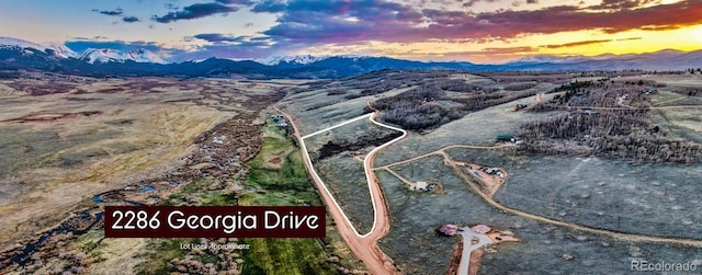 aerial view at dusk featuring a mountain view