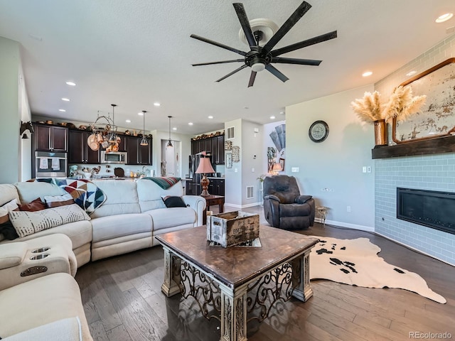 607 Azalea St, Brighton, CO 80601 - living room featuring dark wood-type flooring, ceiling fan, recessed lighting, and a glass covered fireplace