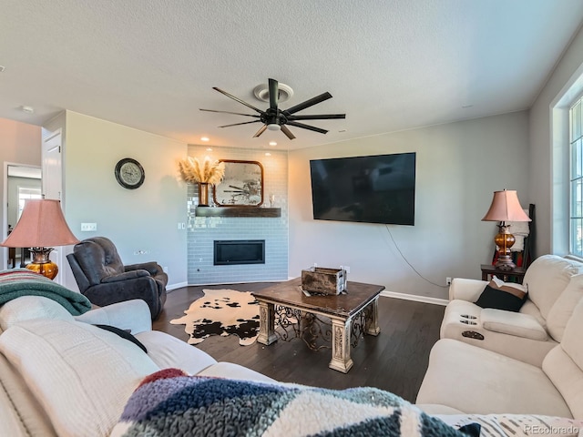 607 Azalea St, Brighton, CO 80601 - living room with a ceiling fan, wood finished floors, a large fireplace, a textured ceiling, and recessed lighting
