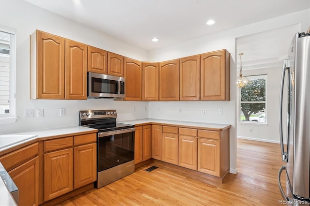 11237 W Ford Dr, Lakewood, CO 80226 - kitchen featuring stainless steel appliances, light wood finished floors, light countertops, recessed lighting, and hanging light fixtures