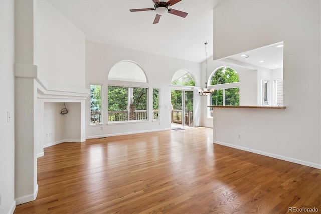 11237 W Ford Dr, Lakewood, CO 80226 - unfurnished living room featuring high vaulted ceiling, a ceiling fan, light wood-style floors, and a chandelier